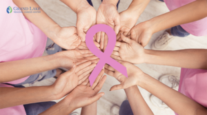 Circle of hands with pink ribbon